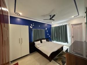 Un dormitorio con una cama y una pared azul. en Hotel Goludev Valley View, en Nainital