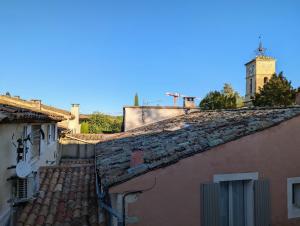 an alley between two buildings with a clock tower at L'Aiguebelle in Céreste