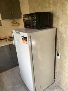 a microwave on top of a refrigerator in a kitchen at Апартамент зал спальня кухня in Yunusobod