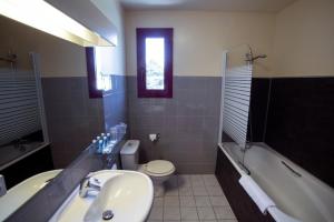a bathroom with a sink and a toilet and a tub at Hotel Médicis in Roussillon en Isere