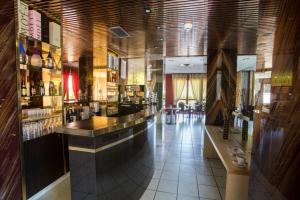 a restaurant with a bar in the middle of a room at Hotel Médicis in Roussillon en Isere +36 photos