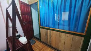 una camera con una porta e una finestra con tende blu di De hemp homestay a Lao Cai
