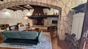 La Foresteria di Podere Muracciolo في توسكانيا: غرفة معيشة مع موقد حجري كبير