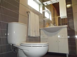 a bathroom with a white toilet and a sink at Casa de Ponta in Topo +14 photos