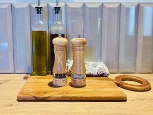 a wooden cutting board with two bottles on a table at "La Forge" avec parking privé in Sète +12 photos