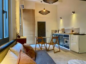 a living room with a couch and a kitchen at "La Forge" avec parking privé in Sète