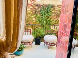 a balcony with two chairs and a fence with plants at "La Forge" avec parking privé in Sète