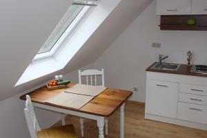 eine Küche mit einem Tisch, einem Waschbecken und einem Fenster in der Unterkunft Dachstudio Sternenblick in Bad Münstereifel