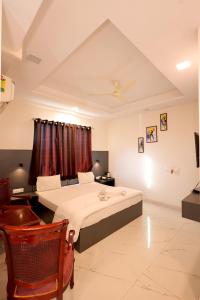a bedroom with two beds and a television in it at Hotel Palace inn Agra in Tājganj