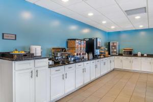 a large kitchen with white cabinets and a blue wall at Country Inn & Suites by Radisson, Rossford - Toledo South in Rossford
