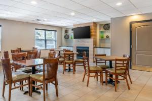 a dining room with tables and chairs and a fireplace at Country Inn & Suites by Radisson, Rossford - Toledo South in Rossford