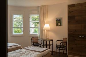 sypialnia ze stołem i krzesłami oraz 2 oknami w obiekcie Apartment am Hofgarten w mieście Innsbruck