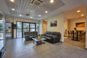 Una sala de estar con dos sofás de cuero y una mesa. en Comfort Aparthotel Carcassonne, en Carcassonne