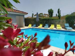 Una piscina con tumbonas al lado de una casa. en Comfort Aparthotel Carcassonne, en Carcassonne