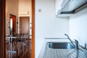 a kitchen with a sink and a table with chairs at Alba dei Grappoli in Spresiano +16 photos