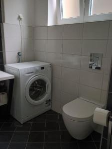 a bathroom with a washing machine and a toilet at Lang's square apartment in Zagreb