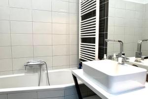 a white bathroom with a sink and a tub at Lang's square apartment in Zagreb +12 photos