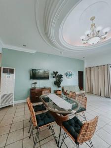 a dining room with a glass table and chairs at Casa Vista by Hooga Home Bungalow Guest House in Talisay +74 photos
