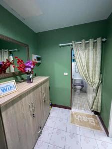 a bathroom with a toilet and a green wall at Ciao Bella GuestHouse & Bistro in Kata Beach +56 photos