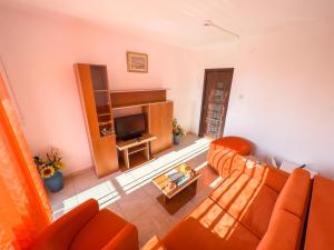 a living room with orange furniture and a television at HOTEL DUNĂREA in Mamaia