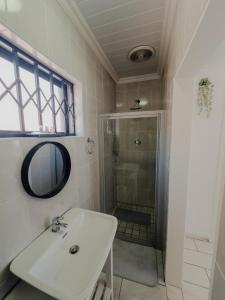 a bathroom with a sink and a shower at Gaiaqua Guesthouse in Gqeberha +43 photos