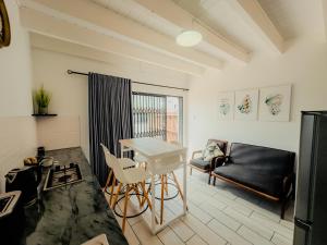 a living room with a table and a couch at Gaiaqua Guesthouse in Gqeberha