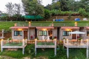 a house with a porch and a woman standing in front of it at ม่อนหนาว ลานกางเต็นท์ in Mon Jam +13 photos