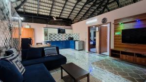 a living room with a couch and a flat screen tv at Encanto Farmstay Resort in Mysore