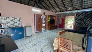 a kitchen and living room with a table in a room at Encanto Farmstay Resort in Mysore
