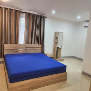 a bedroom with a blue bed in a room at Chiang Mai: Quiet BDR for Two in Green Area in Chiang Mai