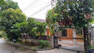 a house with a gate and trees in front of it at Chiang Mai: Quiet BDR for Two in Green Area in Chiang Mai