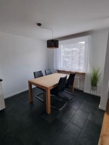 une salle à manger avec une table et des chaises en bois dans l'établissement Schöne neue 2,5 Zimmer Wohnung in Savognin, à Savognin