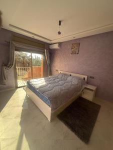 a bedroom with a bed and a large window at Jardin Majorel Appartement en résidence fermée in Marrakech