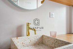 a bathroom with a sink with a gold faucet at GASPAR - Appartement 2 Chambres 4 personnes Dernier étage 75 m2 in Boulogne-Billancourt