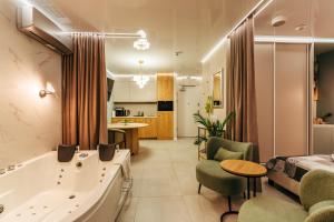 ein Hotelzimmer mit einer Badewanne und einem Schlafzimmer in der Unterkunft Apartamenty z Jakuzzi Perłowa Przystań Rent Kołłątaja in Kołobrzeg