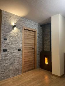 a room with a wooden door and a brick wall at Al Bait de Luiseto in Bormio