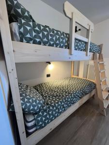 two bunk beds in a room with a ladder at Al Bait de Luiseto in Bormio