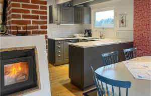 a kitchen with a fireplace and a table with chairs at 4 Bedroom Cozy Home In Beddingestrand in Beddinge Strand +11 photos