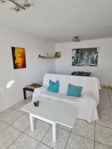 a living room with a white couch and a coffee table at Casa Eowyn in Puerto del Carmen