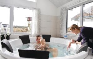 a man and woman in a bath tub with a baby at Awesome Home In Ringkøbing With Sauna in Klegod