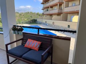 eine Bank auf einem Balkon mit Poolblick in der Unterkunft Malaga Mijas Costa Pool Nuevo Piso in Mijas Costa