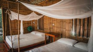 a bedroom with two beds and a canopy bed at Chez Beo Homestay in Ninh Binh