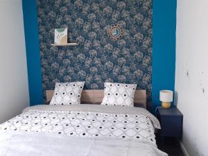 sypialnia z łóżkiem i niebieską ścianą w obiekcie L'artistique, 4 lits, 2 chambres, stationnement gratuit, spacieux, atypique w Amiens