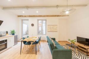 マコンにあるT2 cosy au cœur de Mâcon !のテーブルと椅子のあるキッチンとリビングルーム