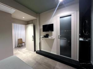 a room with a bathroom with a television and a door at PRIMO RE, Luxury Rooms in Campobasso