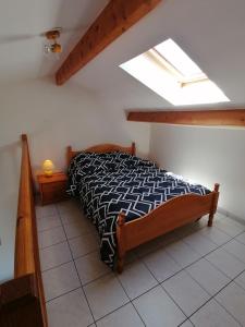 a bedroom with a bed with a black and white comforter at La Côte de Lumière in La Tranche-sur-Mer