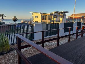 a wooden deck with a fence and a house at Gaiaqua Guesthouse in Gqeberha