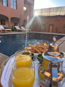a tray of food with a drink and bread next to a pool at Rose Garden Dades in El Kelaa des Mgouna