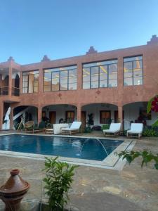 a large building with a swimming pool in front of it at Rose Garden Dades in El Kelaa des Mgouna