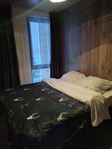 a bedroom with a bed with a wooden head board at Sky loft house in Almaty